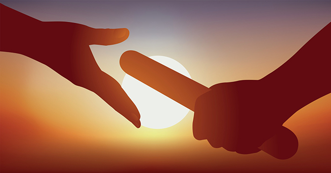 A baton is passed between two hands, with a sunset in the background