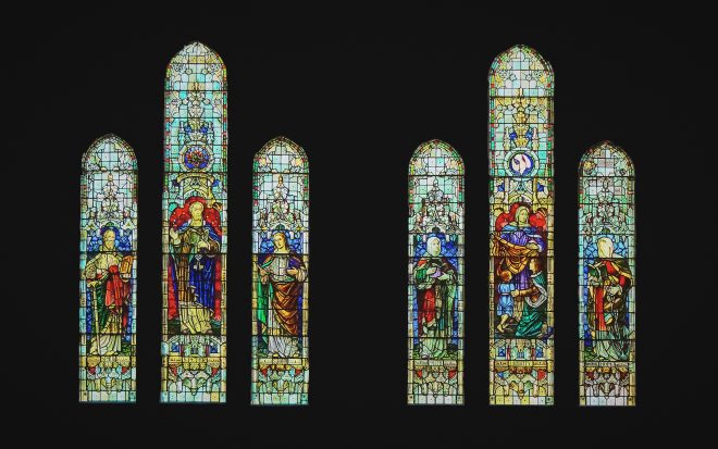 Stained glass windows depicting several male and female saints