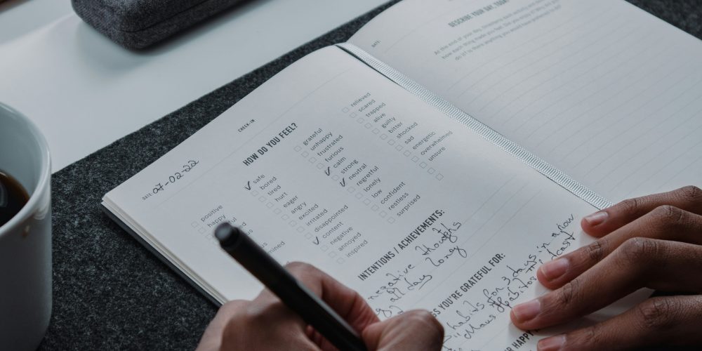 Hands of a person writing in a journal or planner