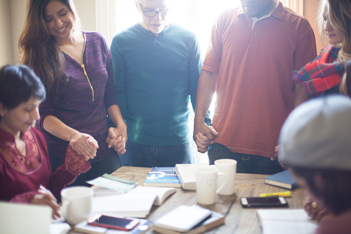 Dr. David Goatley being installed as president of Fuller Theological Seminary in January 2023 People holding hands around a table with open books in front of them