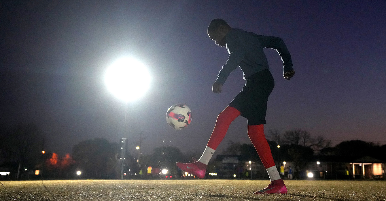 Person playing soccer at night