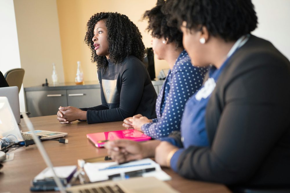 Image of a woman talking while everyone in the room looks at her