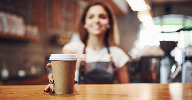 Barista setting a drink on a bar.
