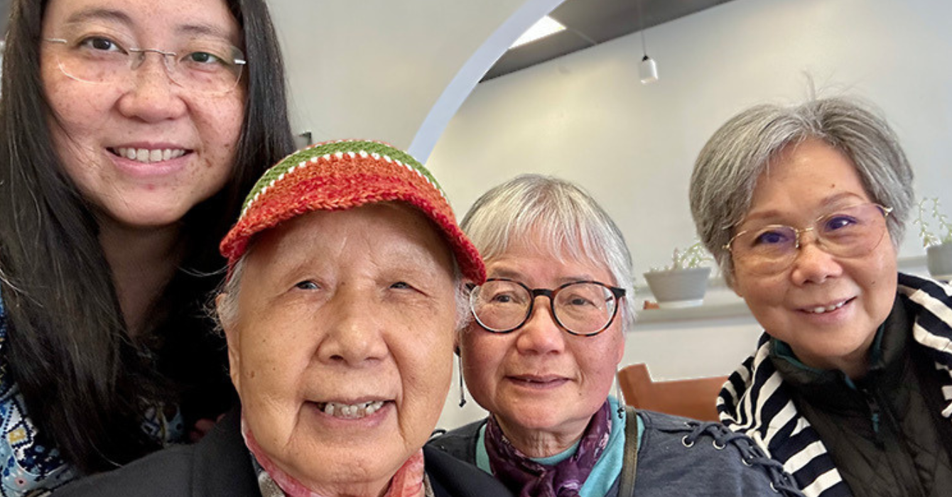 A young woman and three older individuals smiling at the camera
