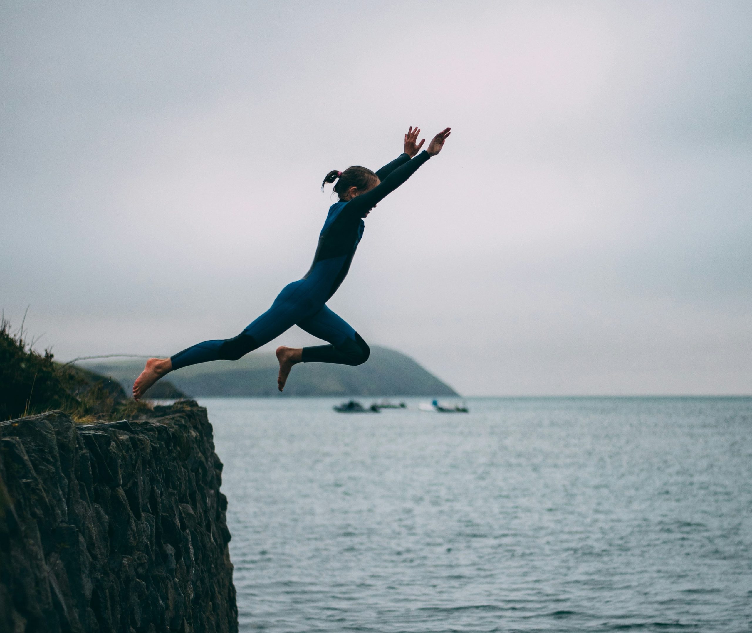 Woman cliff jumping into the water