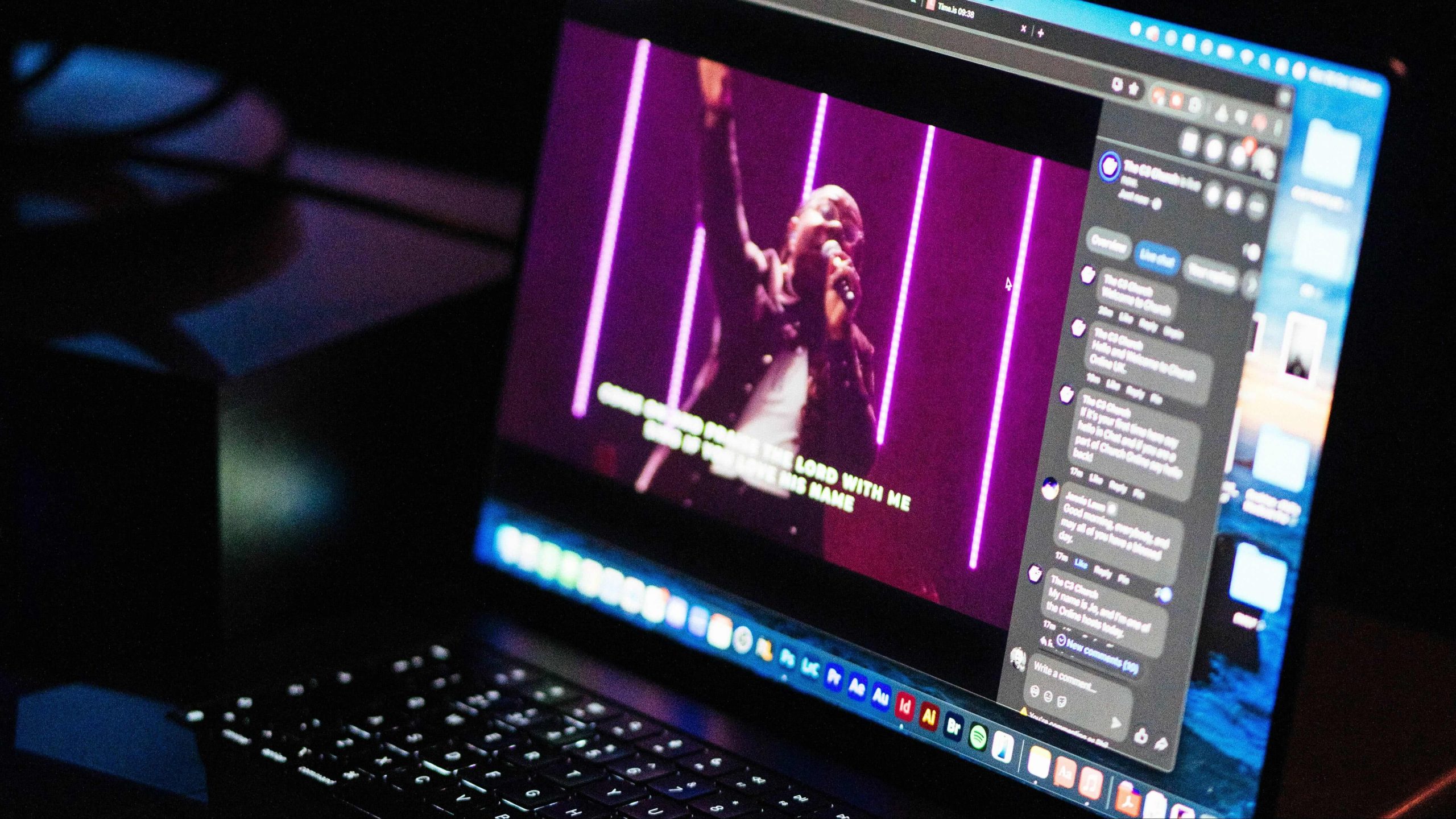An image of a laptop with a person leading worship on the screen