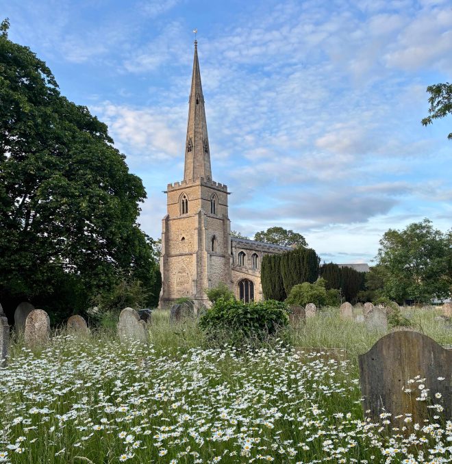 Image of a church and a church graveyard covered in wildflowers