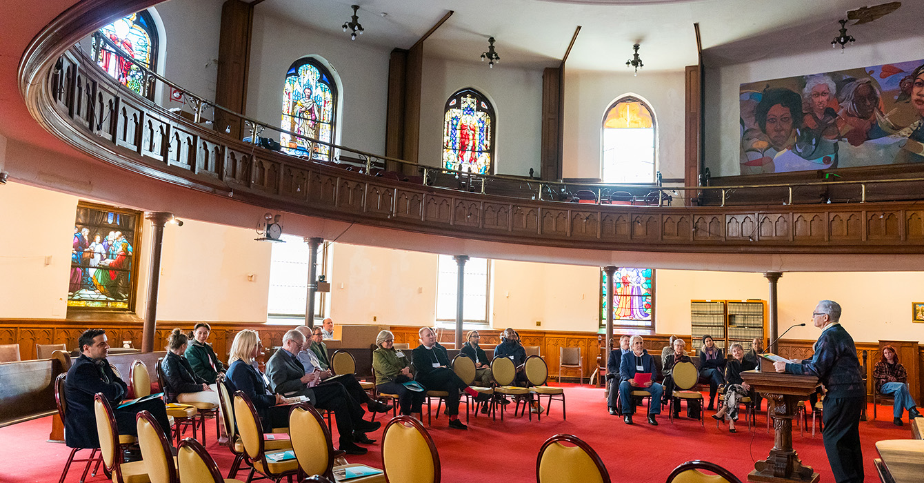 Participants on a tour of the Calvary Center for Culture and Community listen to Rich Kirk, former board president of the center, in the historic church’s chapel.