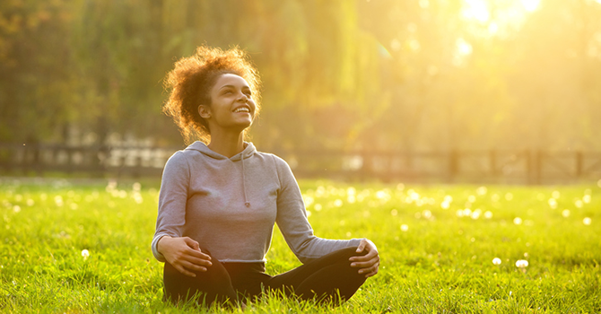 Woman sitting cross-legged in the grass