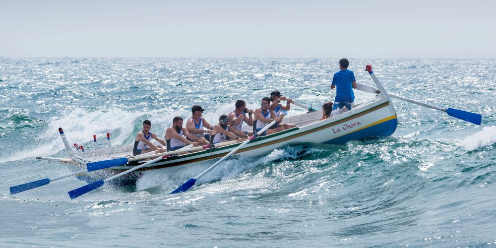 Man directing rowers over choppy waters