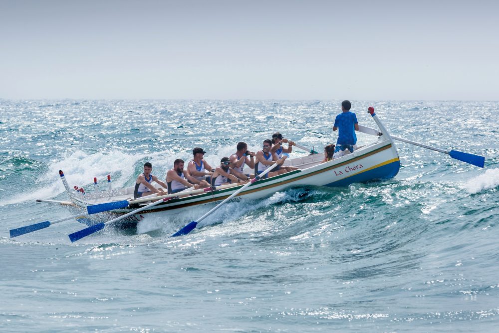 Man directing rowers over choppy waters